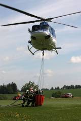 5G6H3122: Foto: Nad hlavami hasičů ve čtvrtek létal vrtulník, cvičili plnění jeho vaku